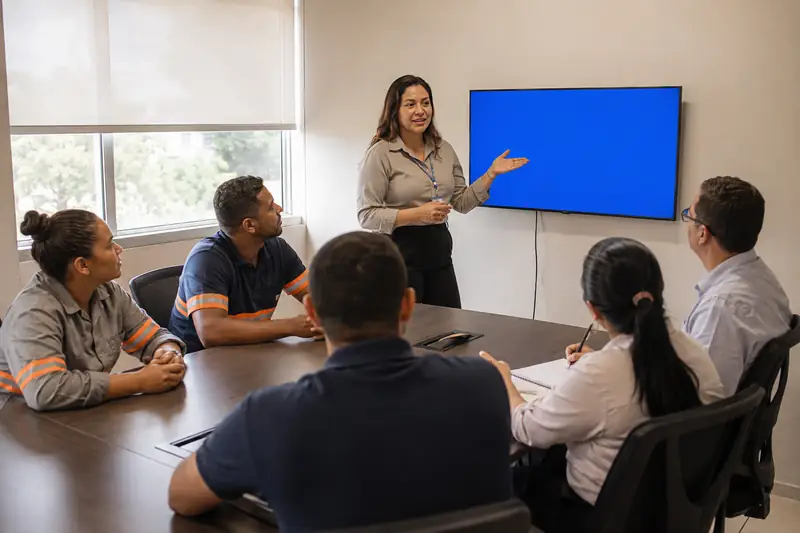 Gestora de RH conversando com colaboradores de diferentes áreas em uma reunião